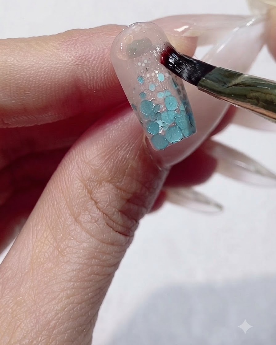 Un pinceau fin appliquant du gel de modelage épais en forme de U autour de la zone des cuticules dun ongle.