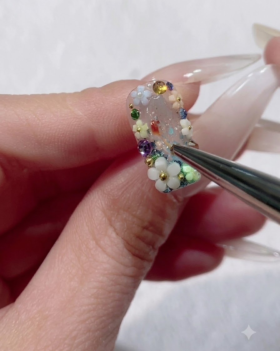 Un pinceau liner fin appliquant un top coat dur autour des bords de la base dun charm floral 3D sur un ongle.