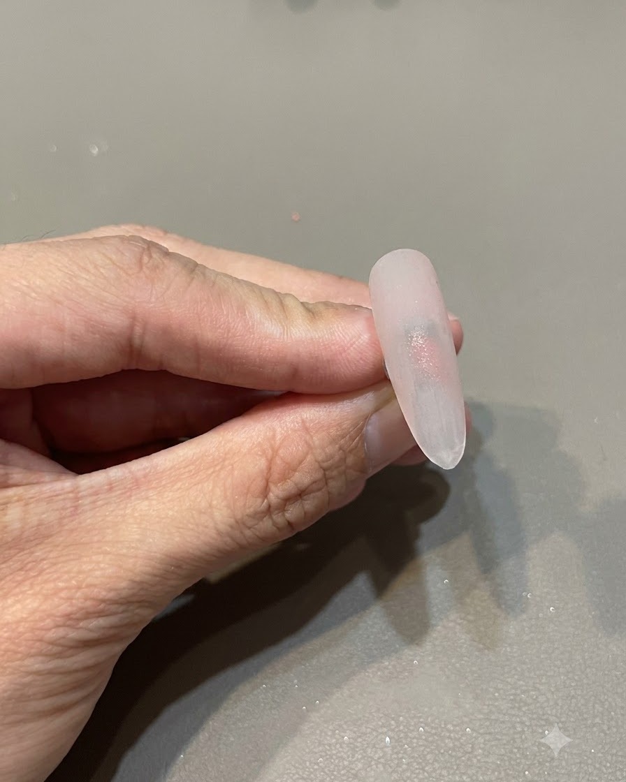 Gros plan sur longle montrant une intensité de couleur rose accrue au centre.