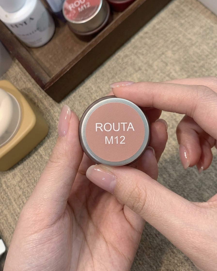 Un petit pot étiqueté Routa M12 contenant une couleur de gel blush rose pêche chaud.