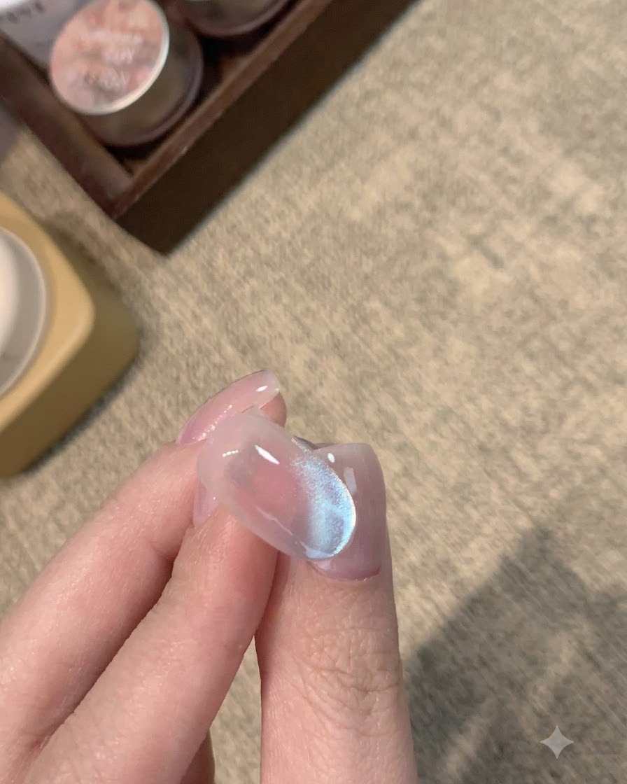 Un ongle mat terminé avec un reflet cat-eye bleu givré en dessous.