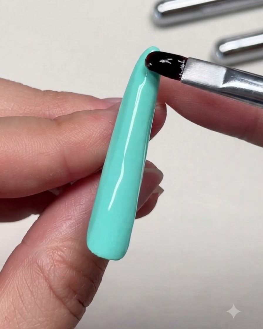 Vue rapprochée dun pinceau nivelant le gel de renfort près de la pointe dune longue extension dongle.