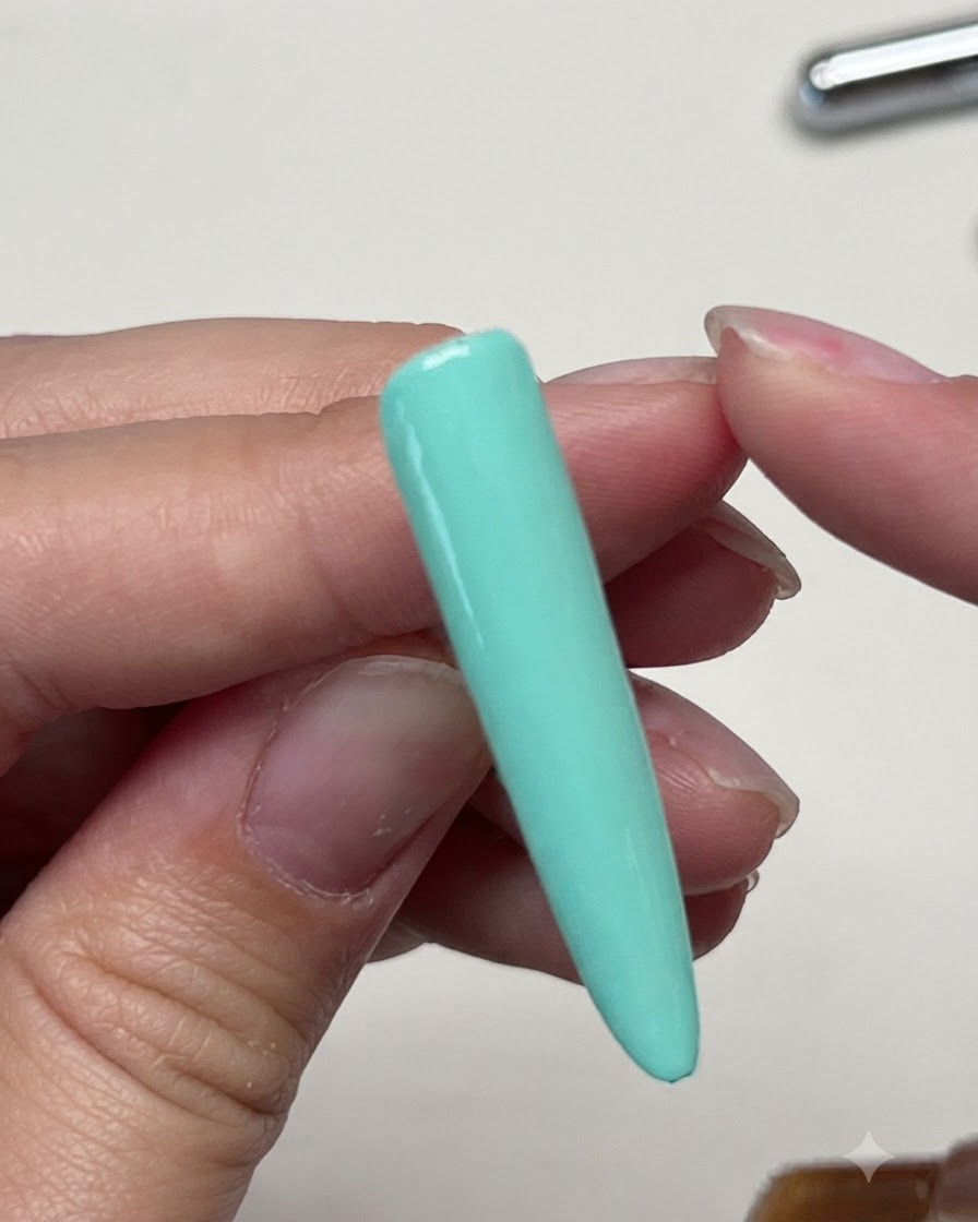 Un pinceau appliquant un top coat mat sur lextension dongle vert menthe unie.