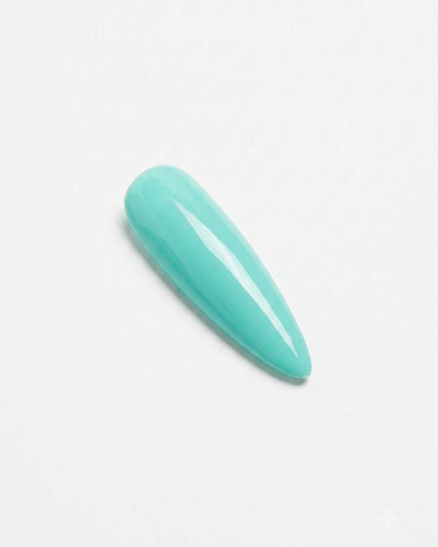 Un ongle vert menthe fini reposant sous une lampe de catalysation UV/LED rose compacte.