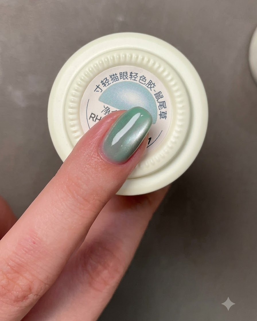 Un pinceau appliquant un vernis gel gris-bleu sur un ongle.