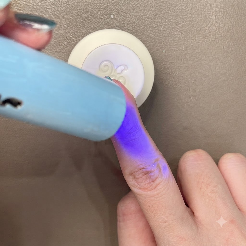 Catalysation dun ongle œil de chat bleu-vert sous une petite lumière UV/LED bleue portable.