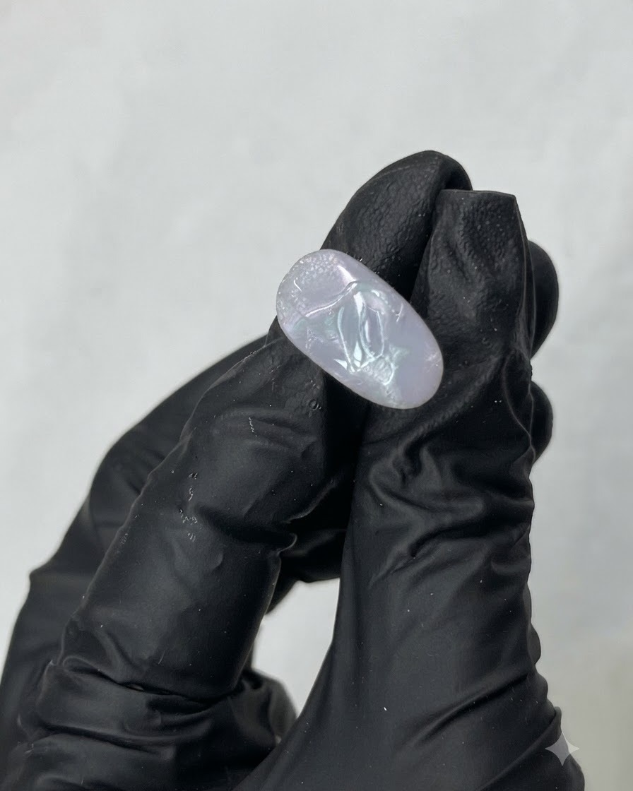 Un outil métallique prélevant du gel de construction transparent M01 à lintérieur dun pot.