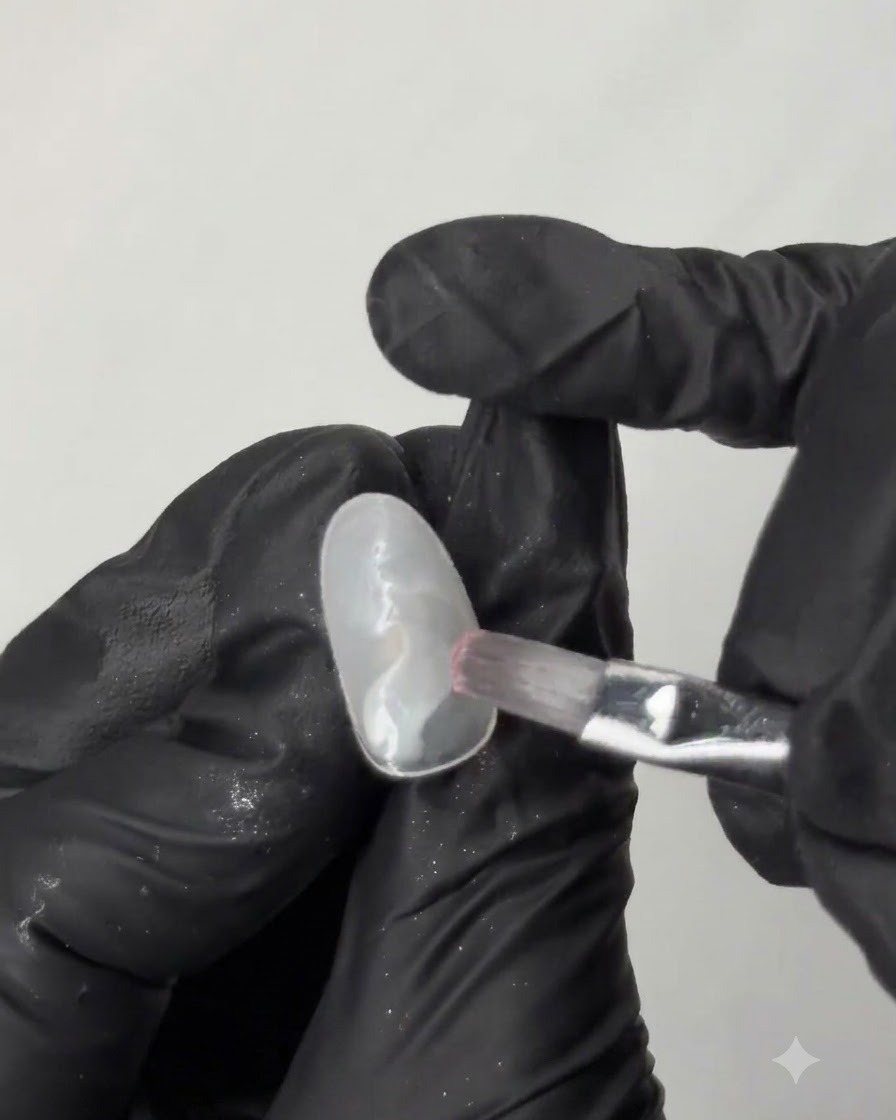 Un pinceau plat lissant du vernis gel vert menthe sur la surface dune capsule dongle dentraînement ovale.