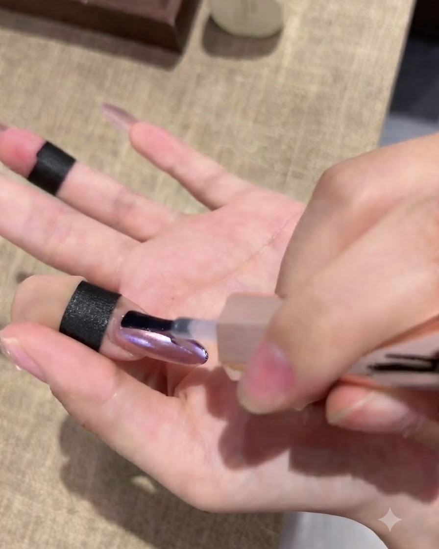 Une main reposant à lintérieur dune lampe de catalysation pour ongles, le bout des doigts illuminé par la lumière.