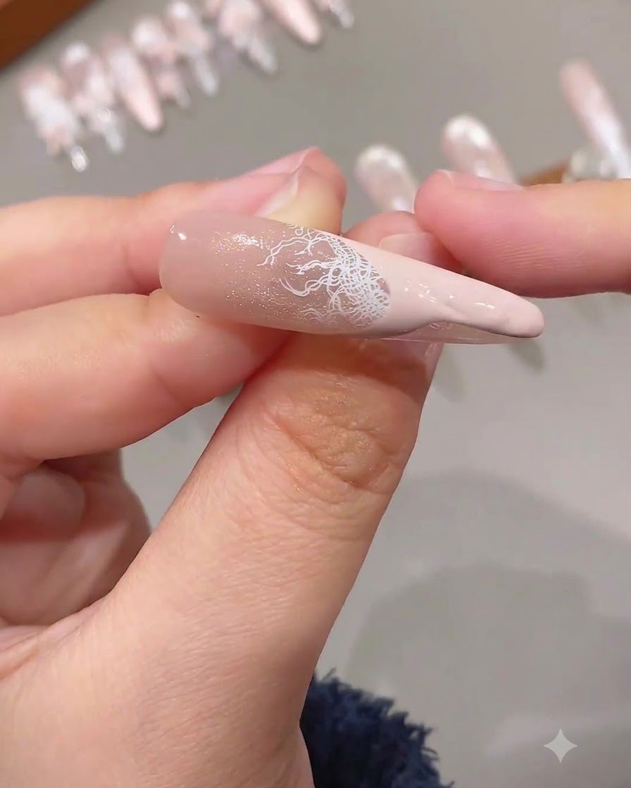 Une french tip terminée présentant une superposition de dentelle blanche complexe combinée à une pointe de couleur rose unie sur un ongle rallongé.