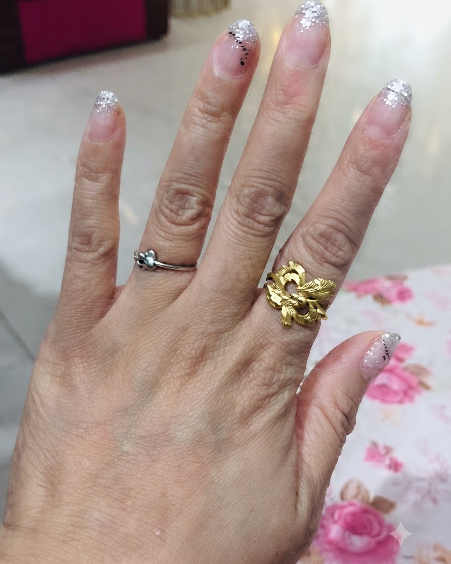 Vue de dessus dune main présentant les cinq doigts avec un design dégradé à paillettes argentées.