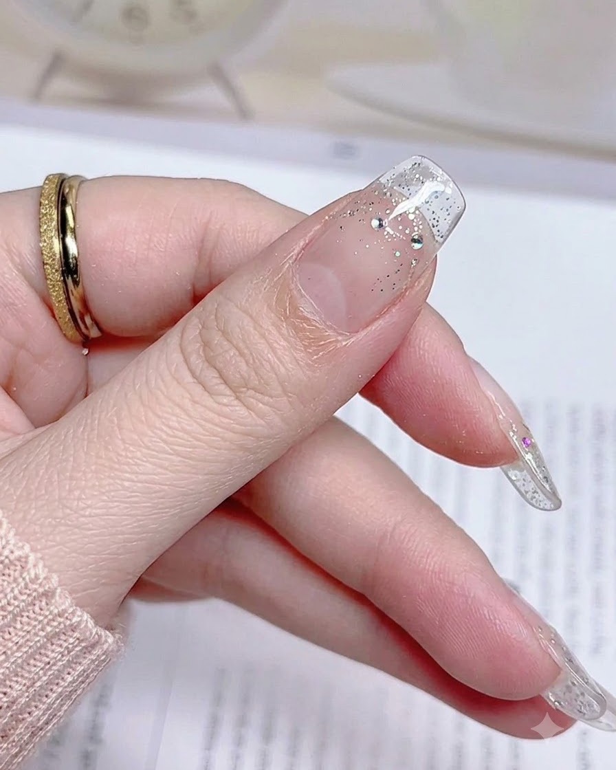Un gros plan dun ongle de pouce terminé après avoir retiré lexcédent de sticker, révélant un bord net.