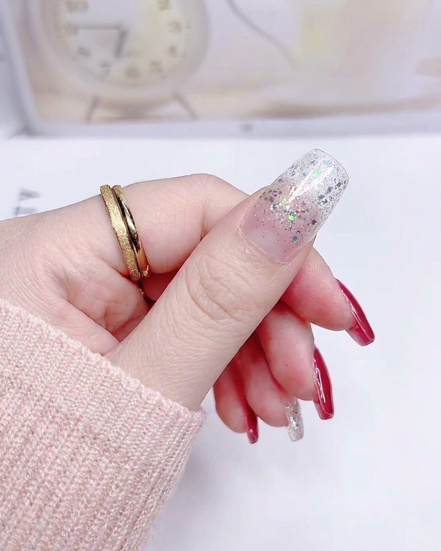 Un ongle avec un sticker à dégradé de paillettes argentées appliqué de manière lisse de la cuticule au bord libre.