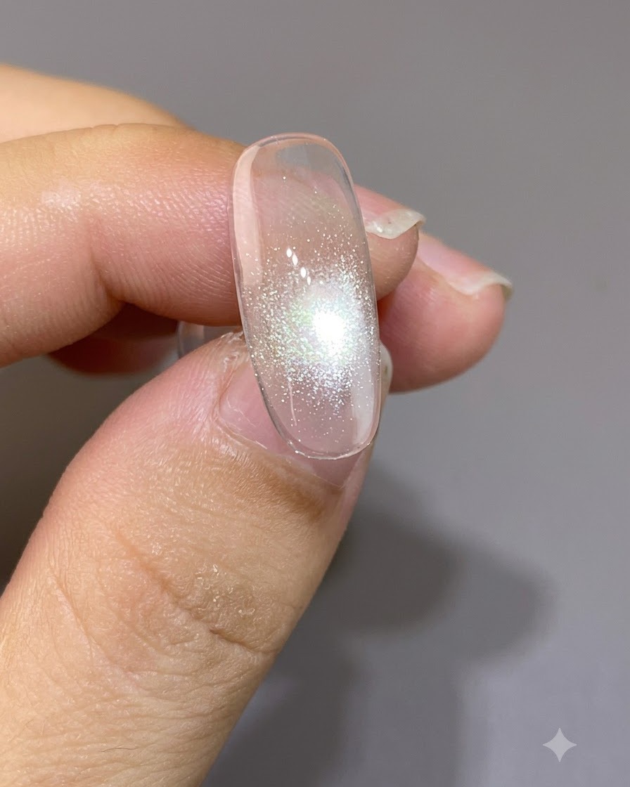 Un aimant positionné de très près au-dessus dun ongle, formant un point focal cat-eye resserré et brillant.