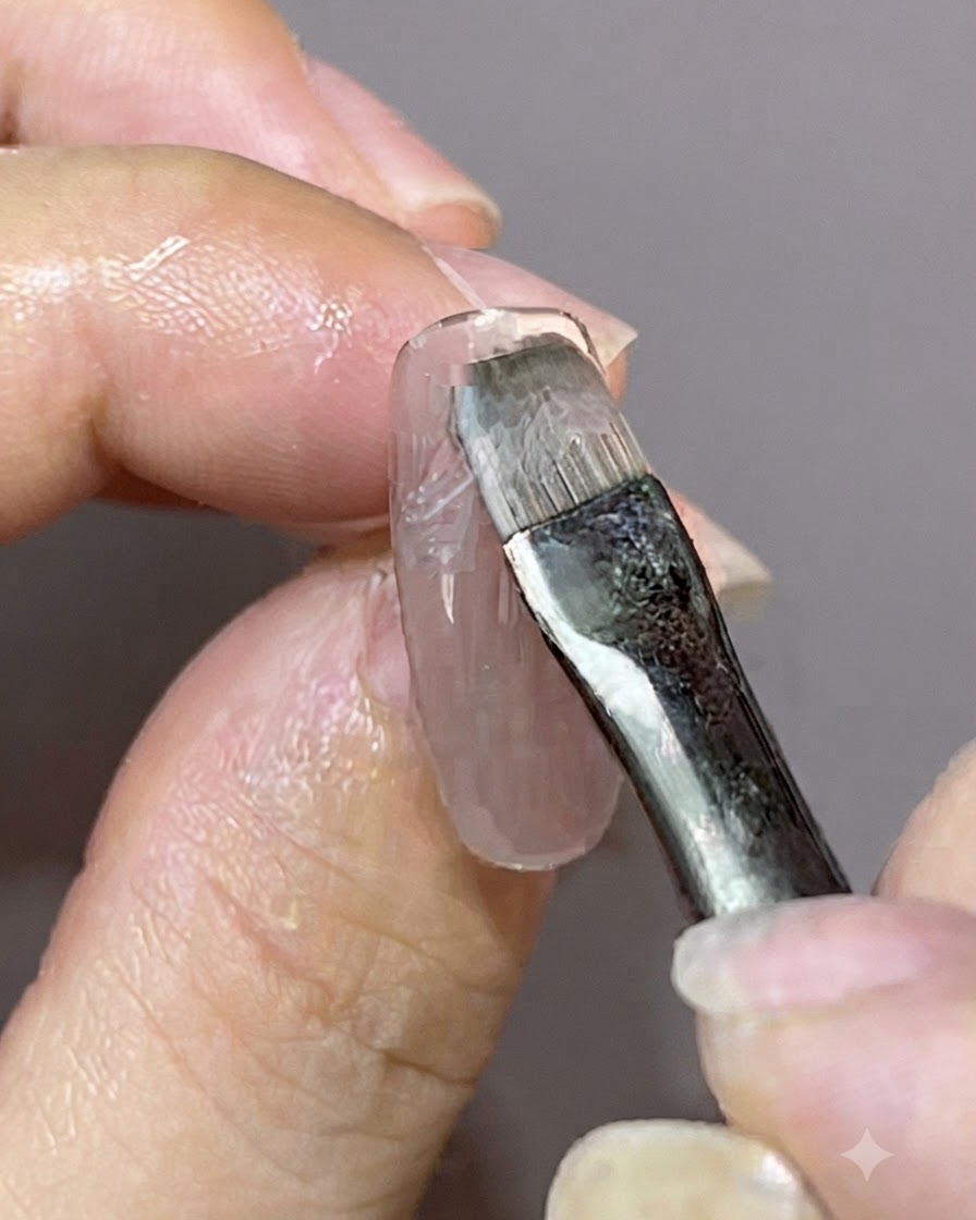Un pinceau de détail appliquant une nouvelle couche de vernis gel sur un motif dongle magnétique existant.