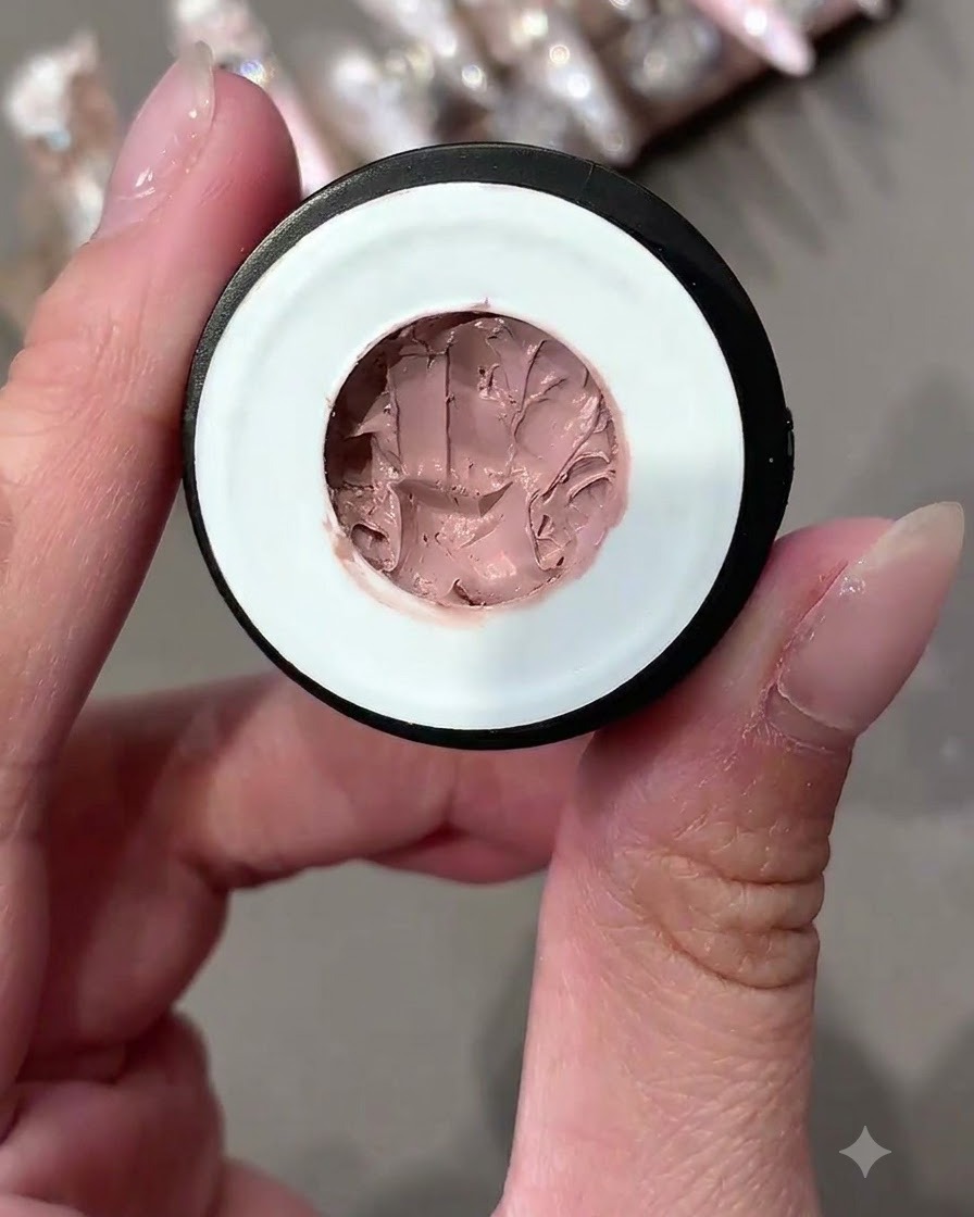 Un pot ouvert de gel pudding solide aux tons roses vu de près.