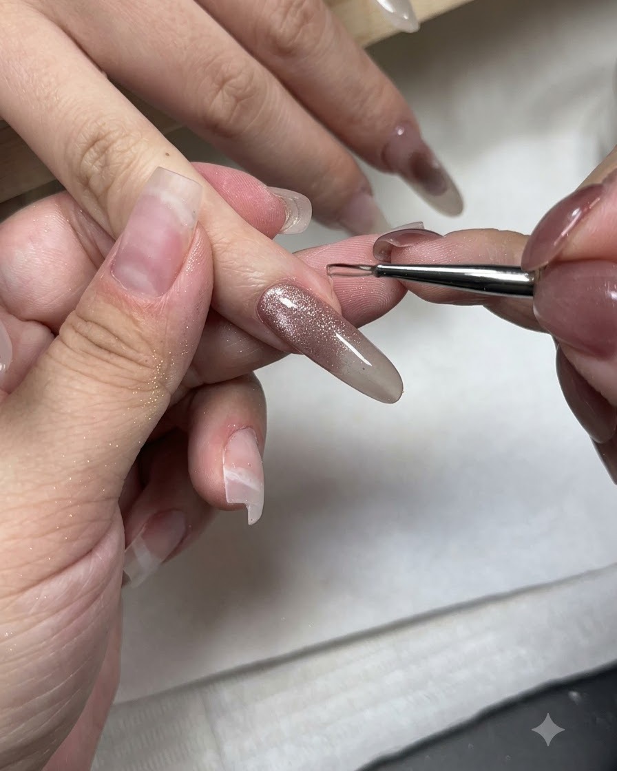 Un pinceau fin de nail art appliquant du gel de modelage sans résidu sur le bout dun ongle en gel œil de chat.