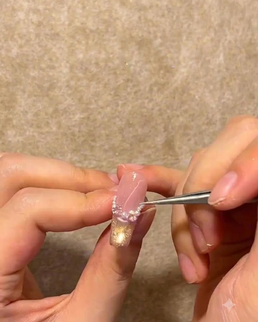 Une paire de pinces métalliques plaçant de minuscules perles blanches et des strass le long de la ligne du sourire French dun ongle.