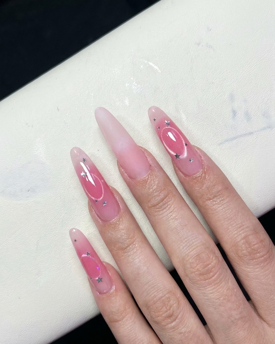Une vue rapprochée de doigts montrant un effet blush rose en dégradé au centre des ongles.