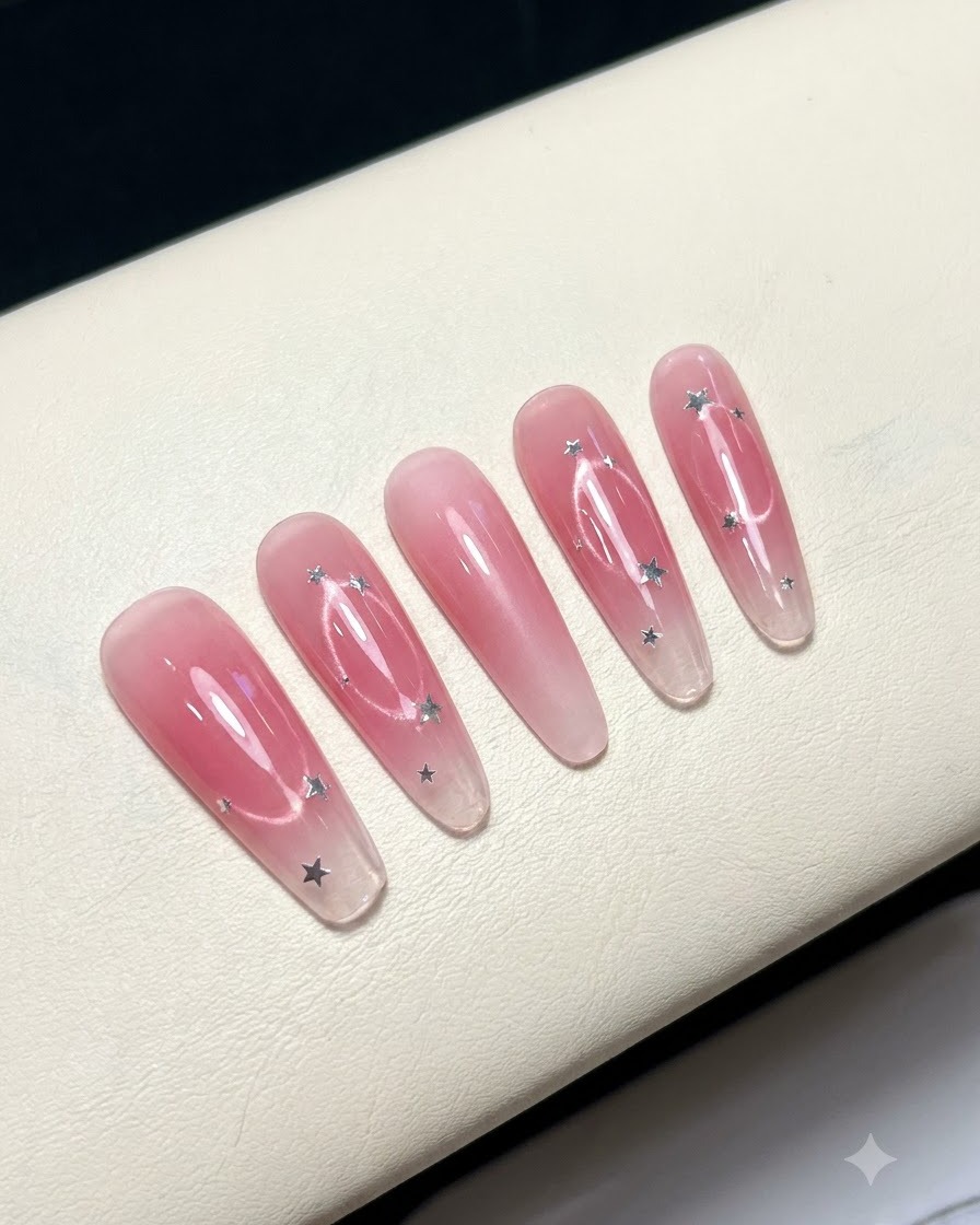 Cinq faux ongles disposés sur une surface blanche affichant un design de centre blush rose.