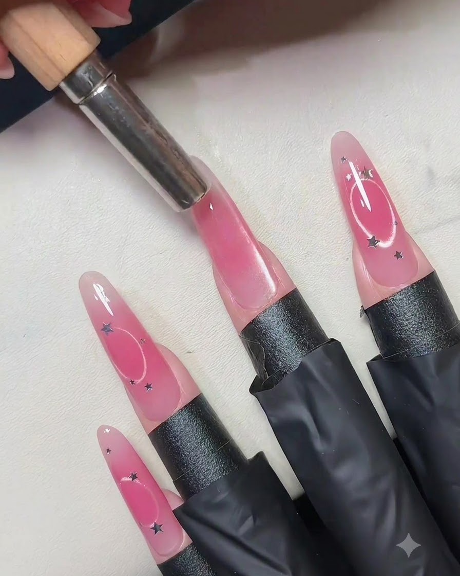 Un aimant cylindrique tenu verticalement au-dessus du centre dun ongle en gel œil de chat rose.