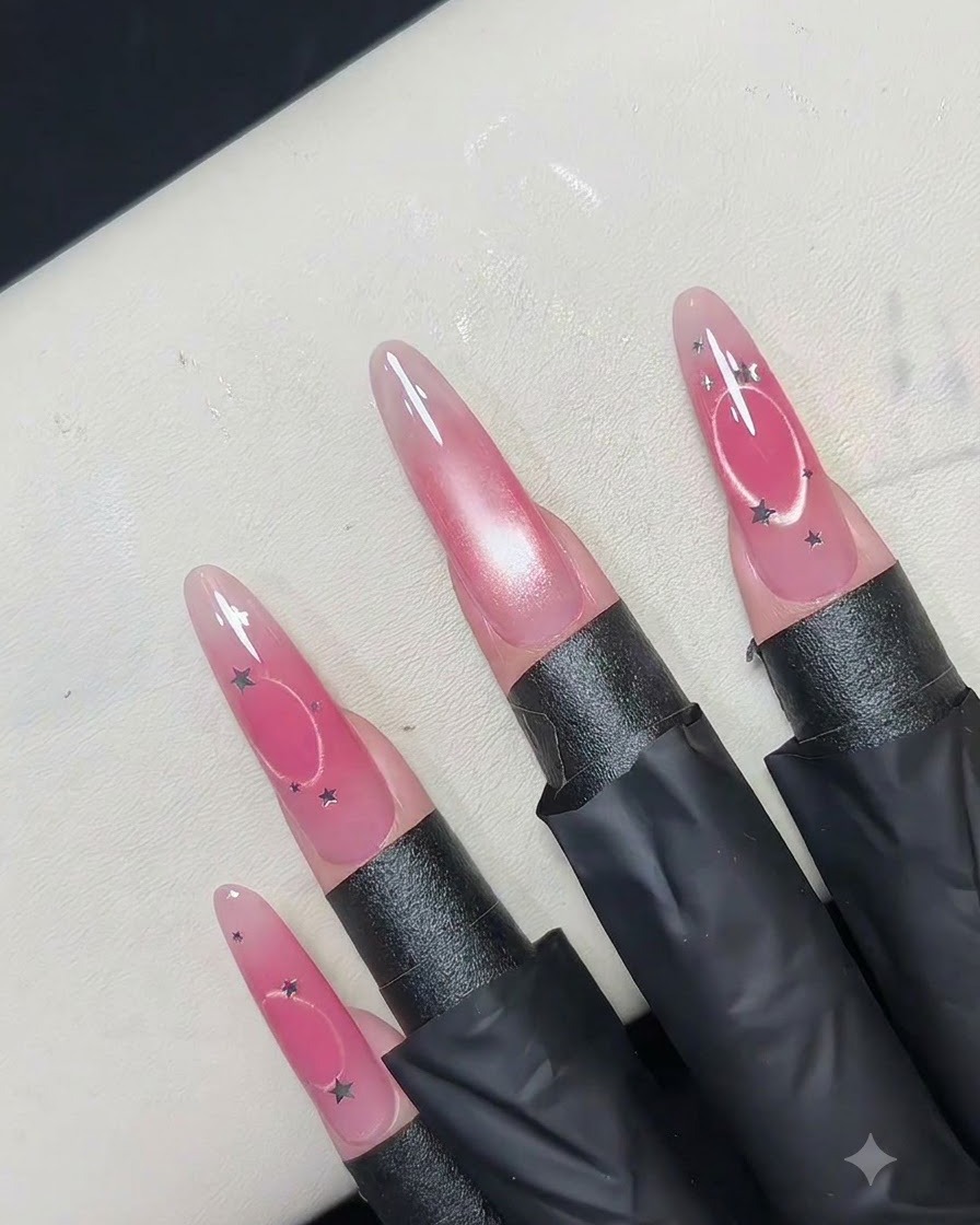 Un outil aimanté circulaire creux tenu au-dessus dun ongle rose pour repousser les reflets magnétiques vers lextérieur en un anneau.
