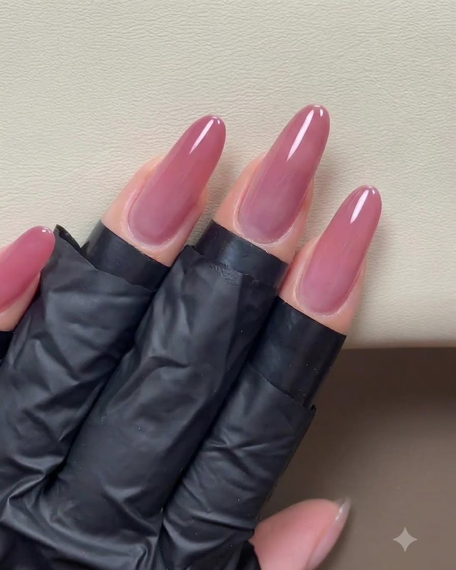 Une application terminée de gel œil de chat rose-doré recouvrant uniformément la surface de longs ongles préparés.