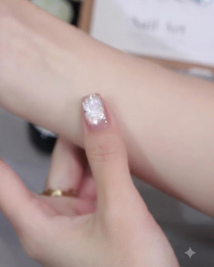 Un pinceau à ongles appliquant uniformément du vernis gel cat-eye rose Bing茉莉 numéro 09 sur la surface dun onglet.