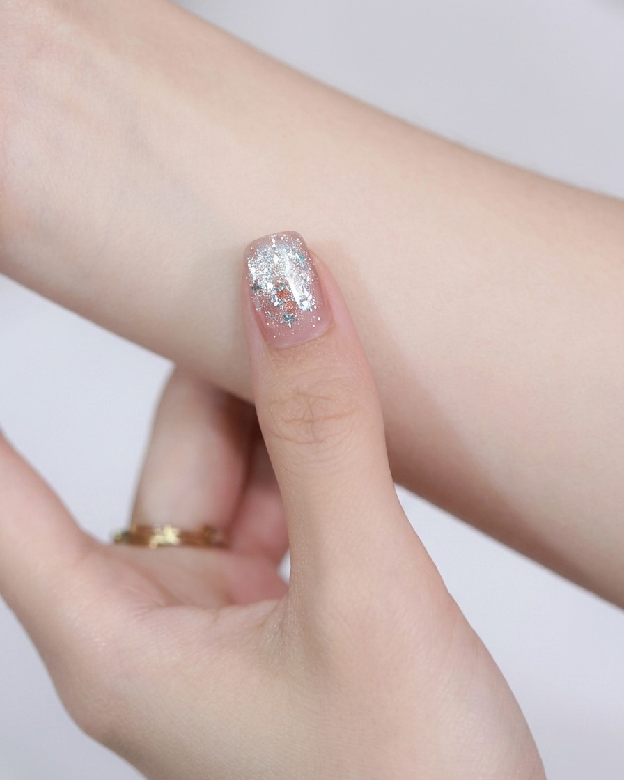 Un aimant rond en acier tenu au-dessus dun ongle peint pour déplacer les particules magnétiques cat-eye.