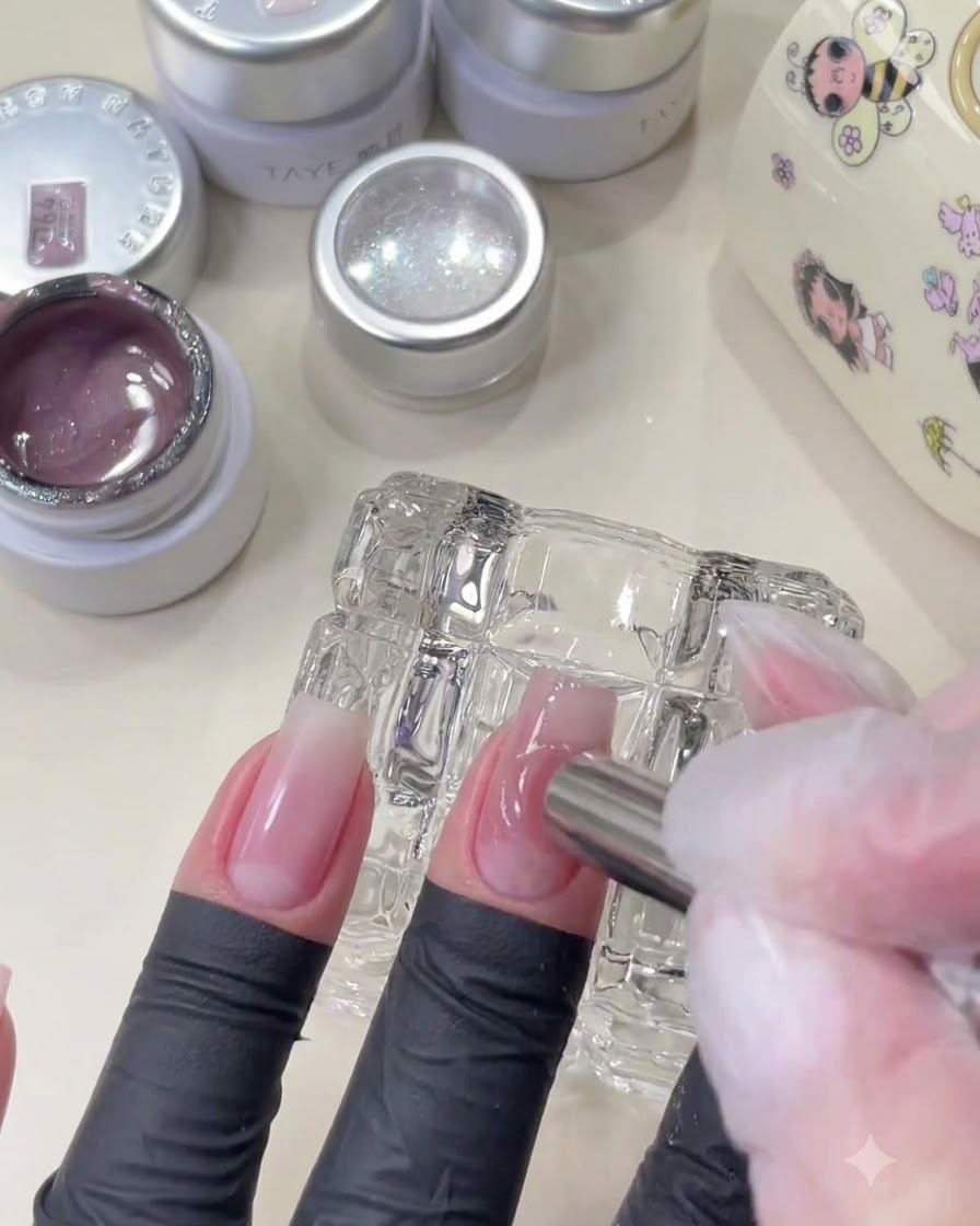 Gros plan dun outil magnétique se déplaçant dans un mouvement circulaire à côté dun ongle rose brillant.