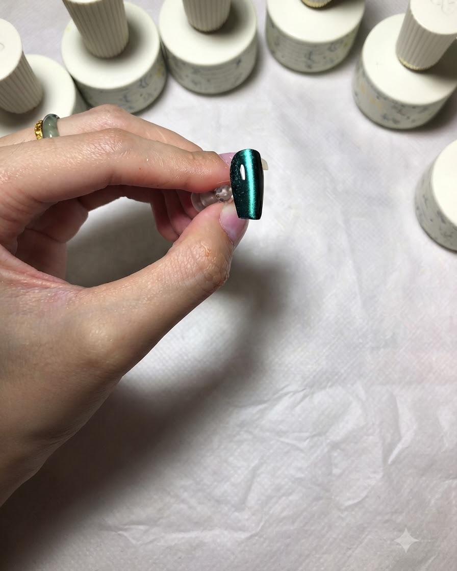 Un ongle cat eye vert terminé montrant une ligne de lumière brillante, nette et centrée.