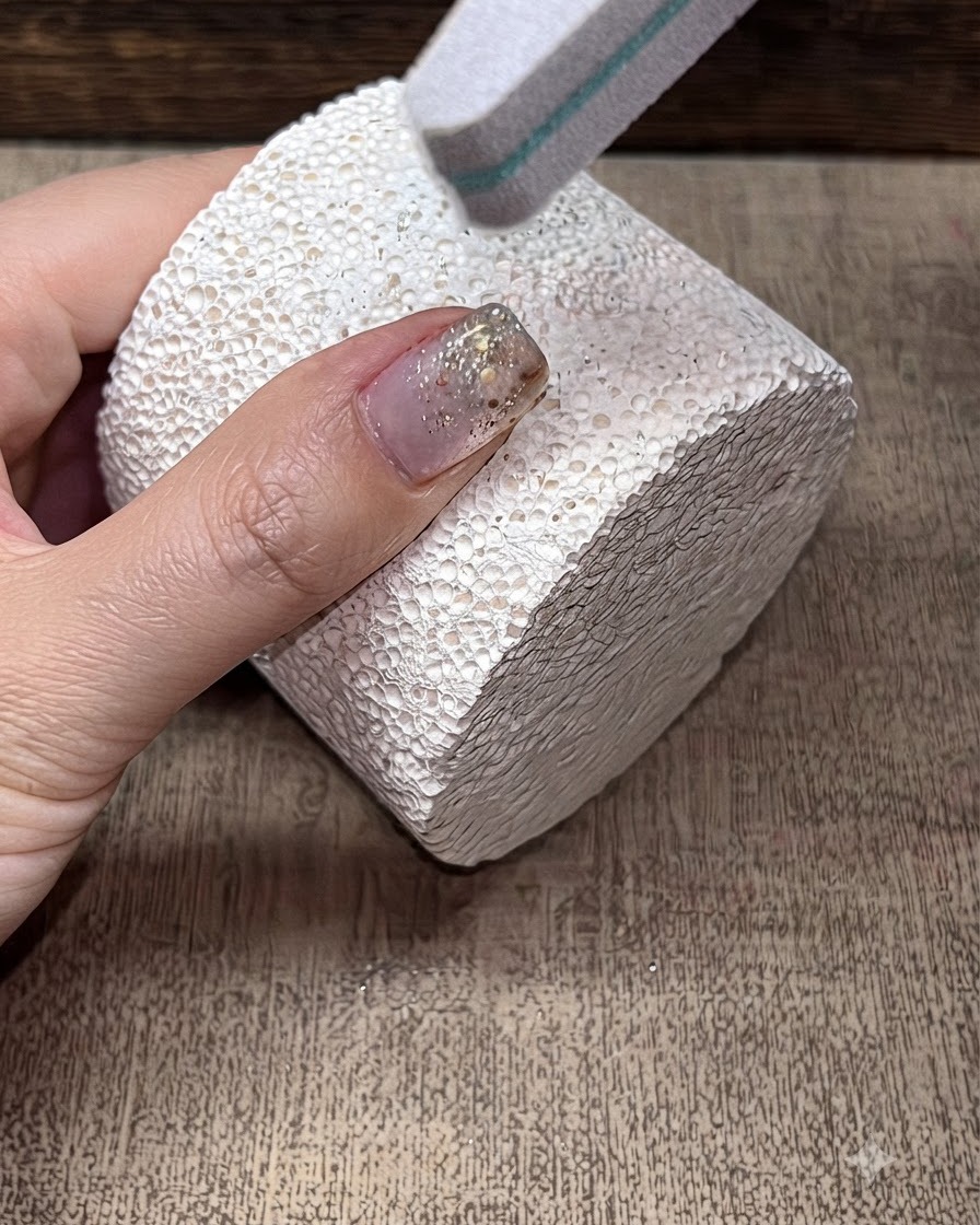 Une lime bloc-polissoir lissant la surface dun ongle manucuré.