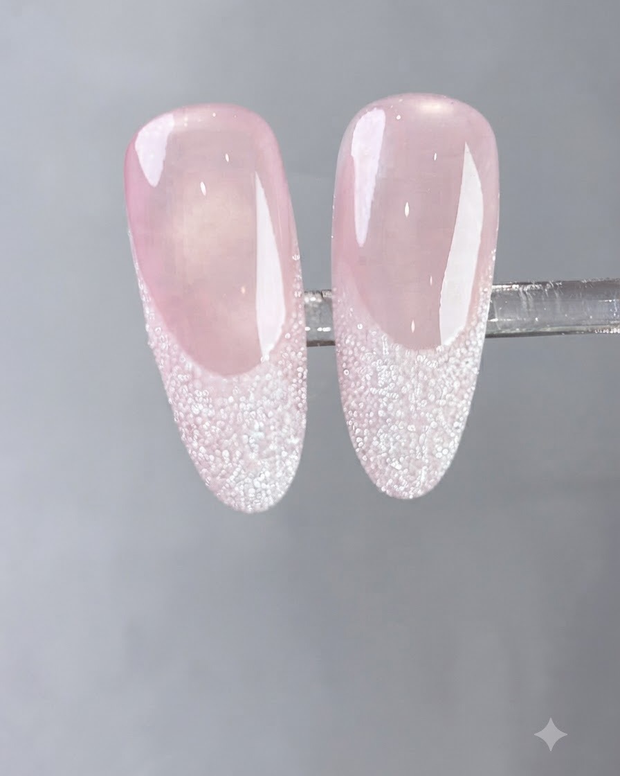 Un pinceau appliquant une couche fluide de gel blanc laiteux sur un ongle naturel.