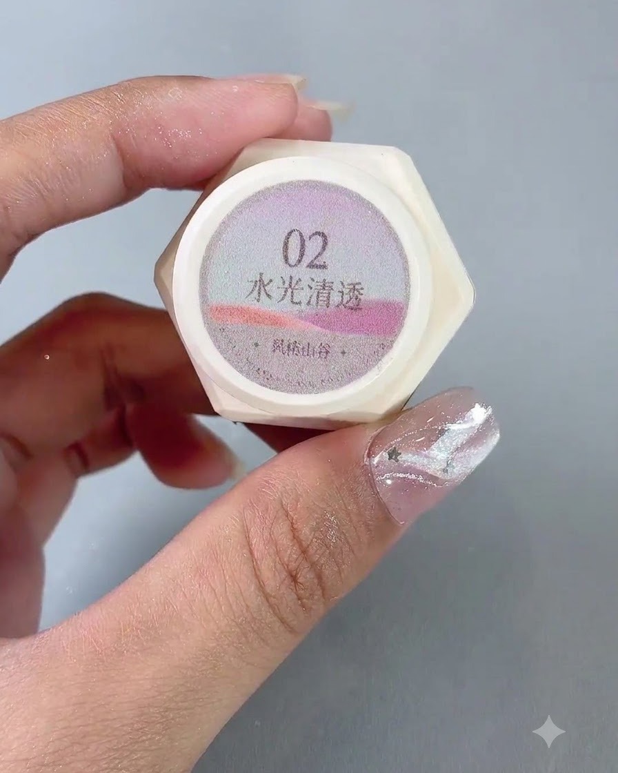 Une paire de mains tenant un pot de gel vernis cat eye translucide numéro 2 effet eau.
