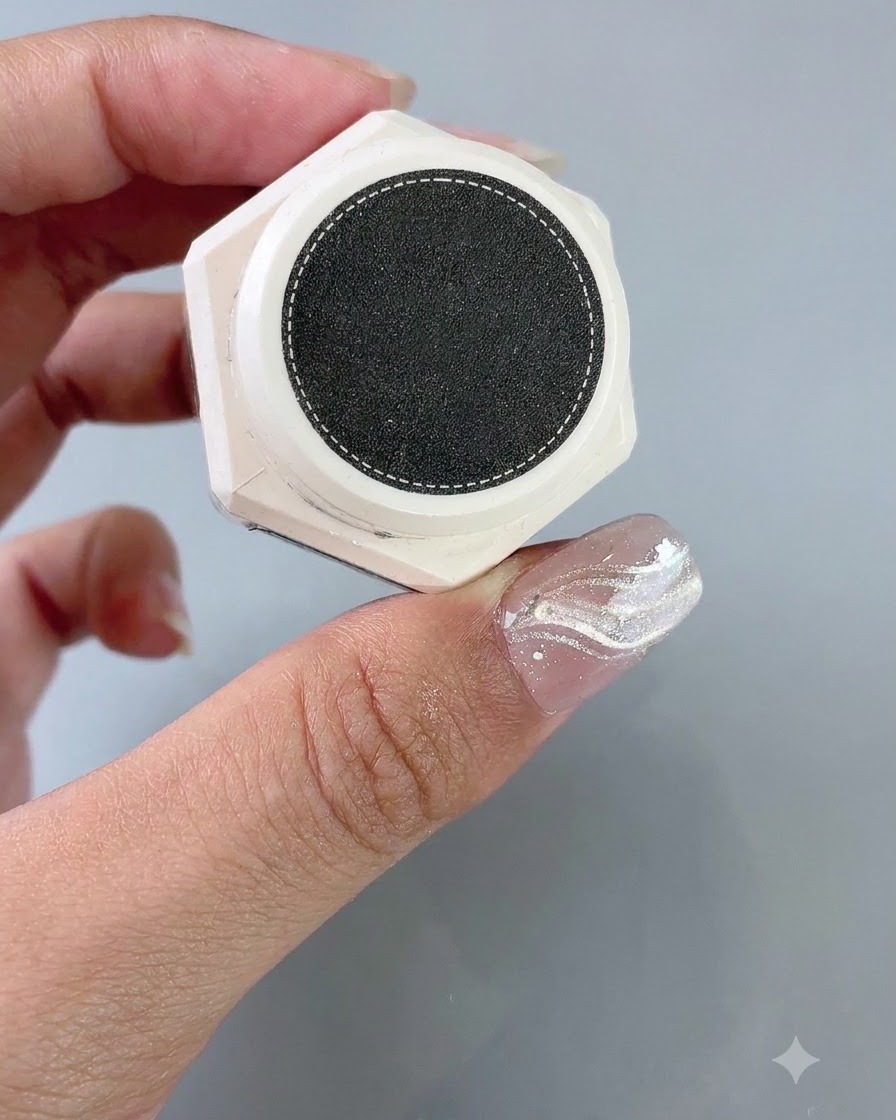 Un pot de gel de texture styling tenu à côté dun ongle muni dun guide autocollant French.