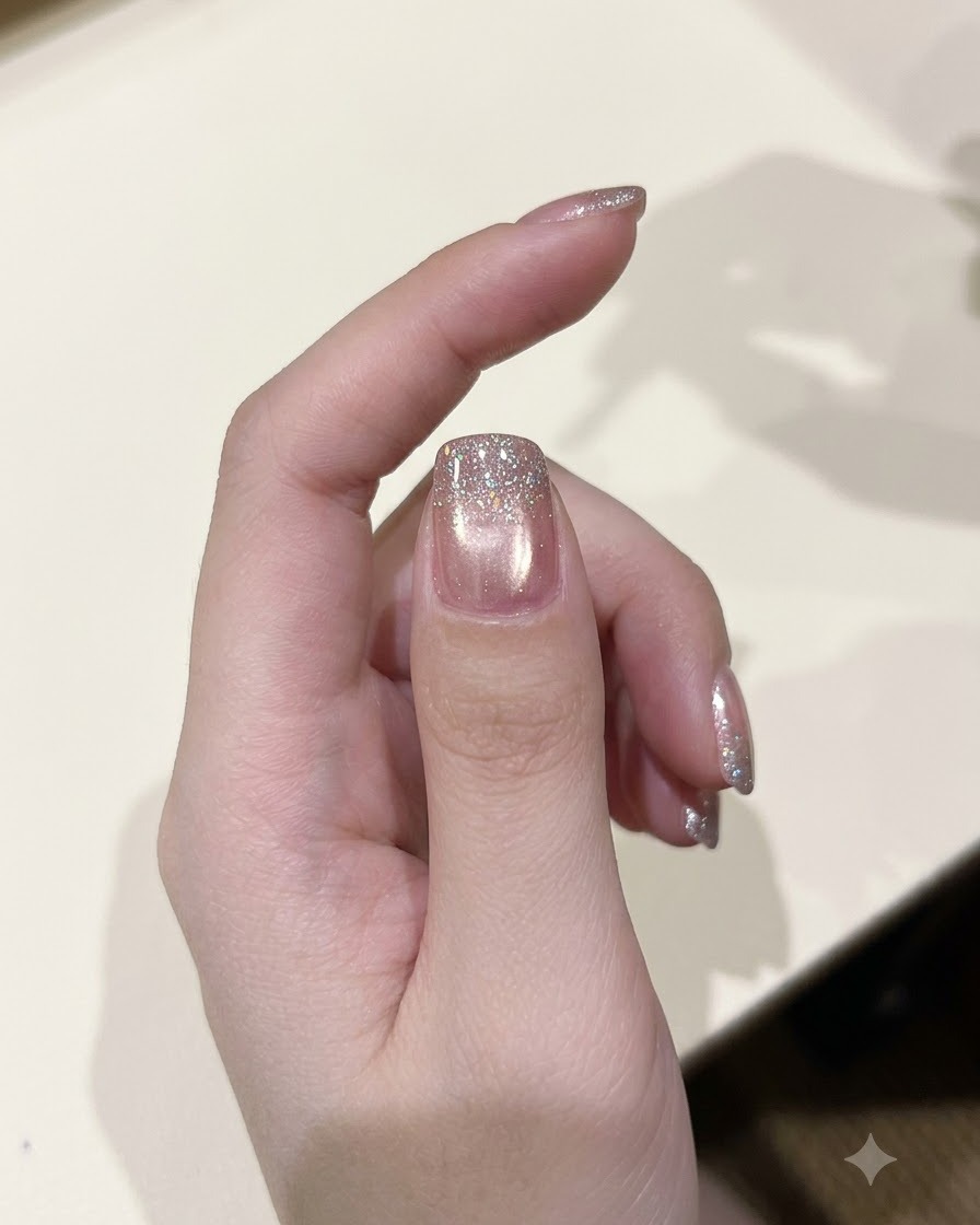 Un pinceau à vernis appliquant une couche de gel pailleté diamant étincelant sur un ongle catalysé.