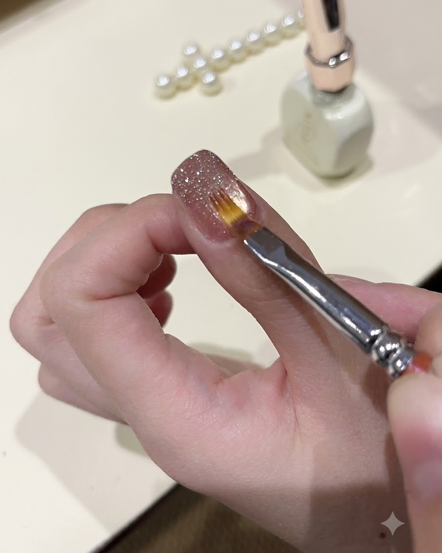 Un pinceau de détail fin lissant le gel pailleté étincelant sur la surface dun ongle manucuré.