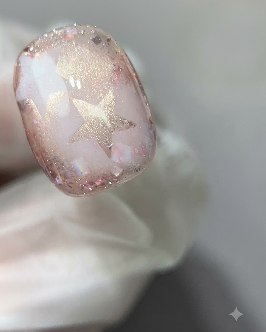 Vue rapprochée dun ongle en gel œil-de-chat rose catalysé sous une lumière de polymérisation.