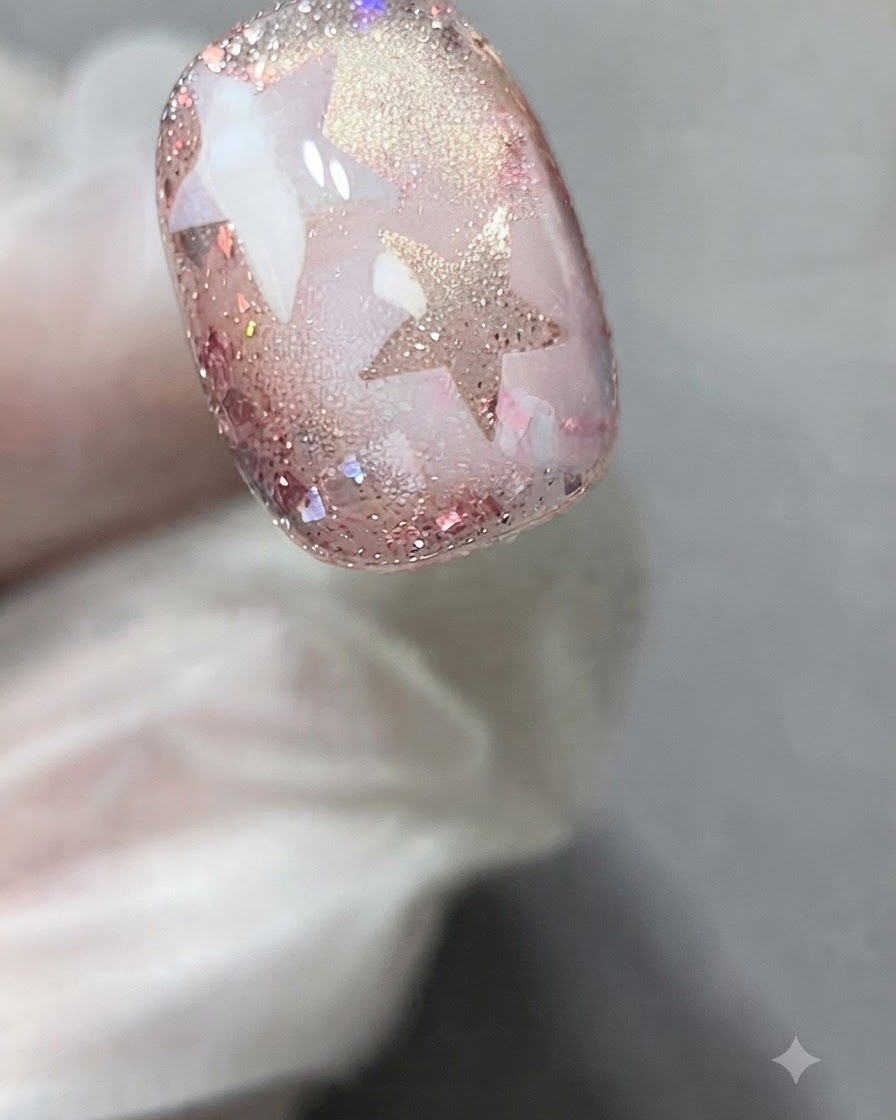 Un autocollant pochoir étoile appliqué précisément sur la surface dun ongle en gel décoré.