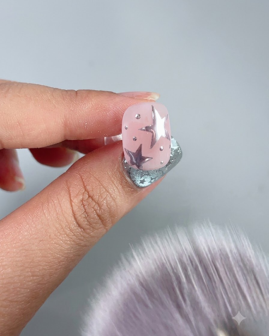 Un pinceau à épousseter doux balayant lexcès de poudre dun ongle décoré.