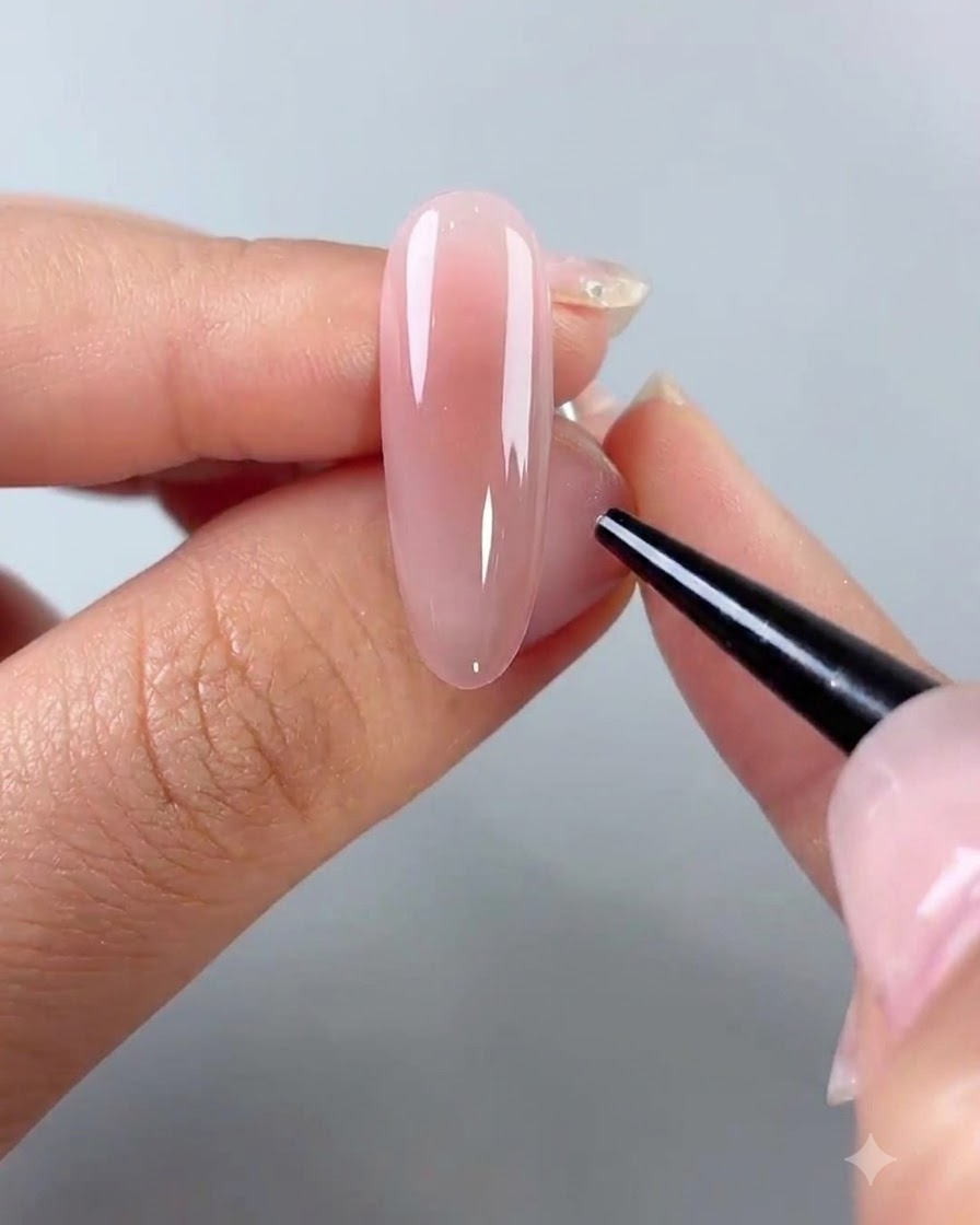 Un outil à pointe fine plaçant de petits embellissements sur la surface dun ongle recouvert de gel.
