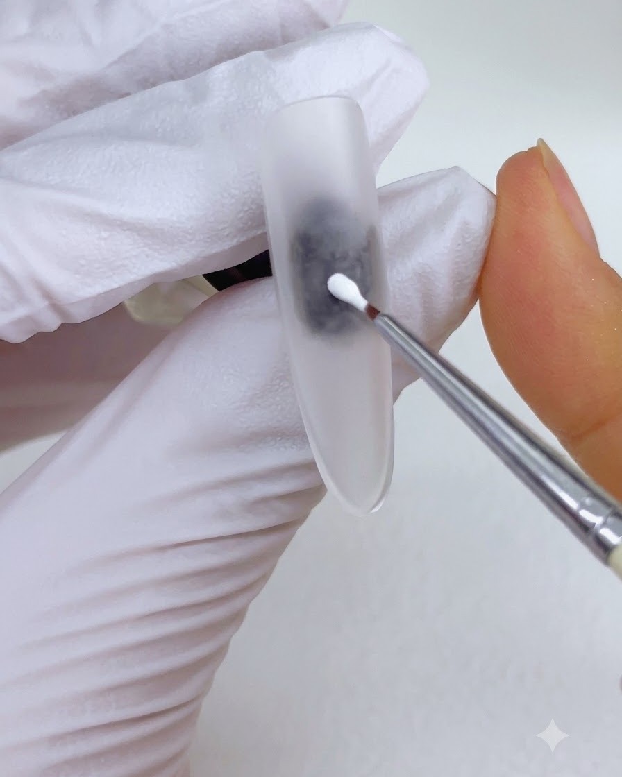 Un pinceau de détail fin plaçant un point de gel de peinture blanc au centre dune surface dongle mate.