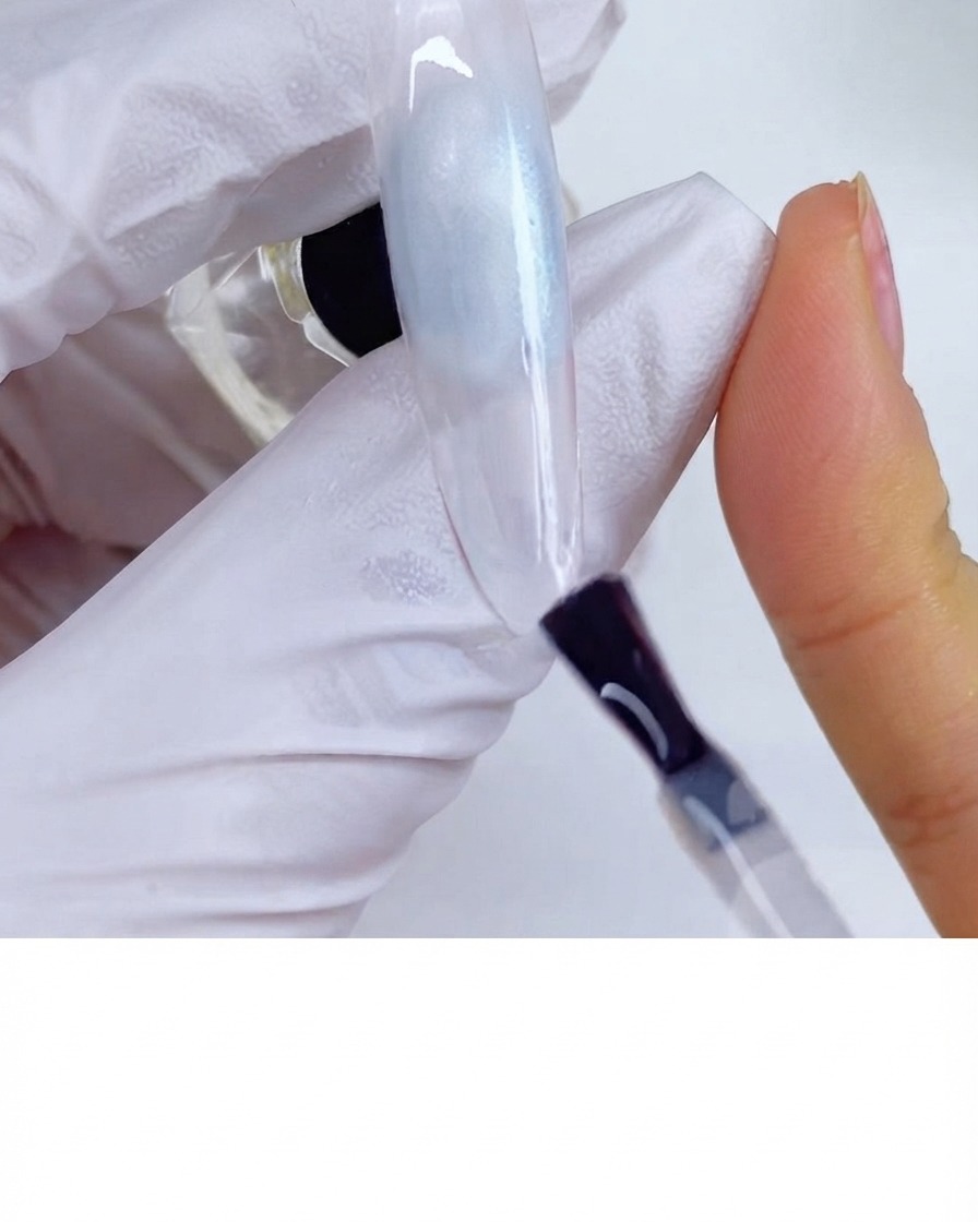 Un pinceau appliquant un top coat mat sur la surface dun ongle.