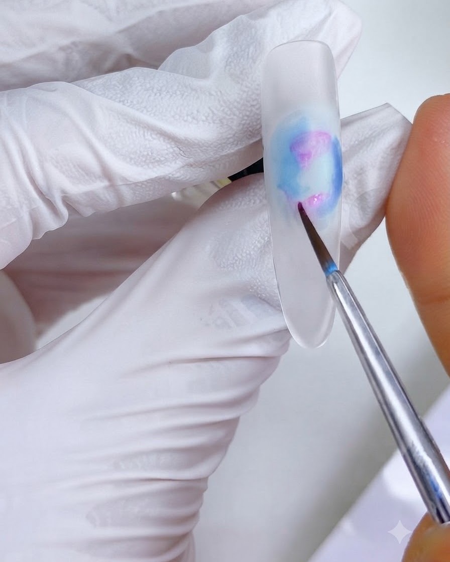 Un pinceau de détail fin appliquant de petites taches dencre rose-magenta sur les régions supérieure gauche et inférieure du design de longle.