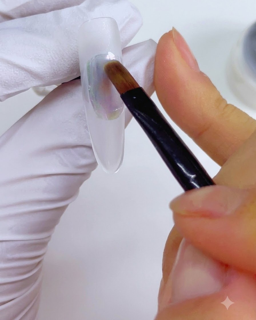 Un pinceau de détail légèrement humidifié avec du cleaner pour ongles et doucement passé sur lapplication dencre multicolore sur longle.
