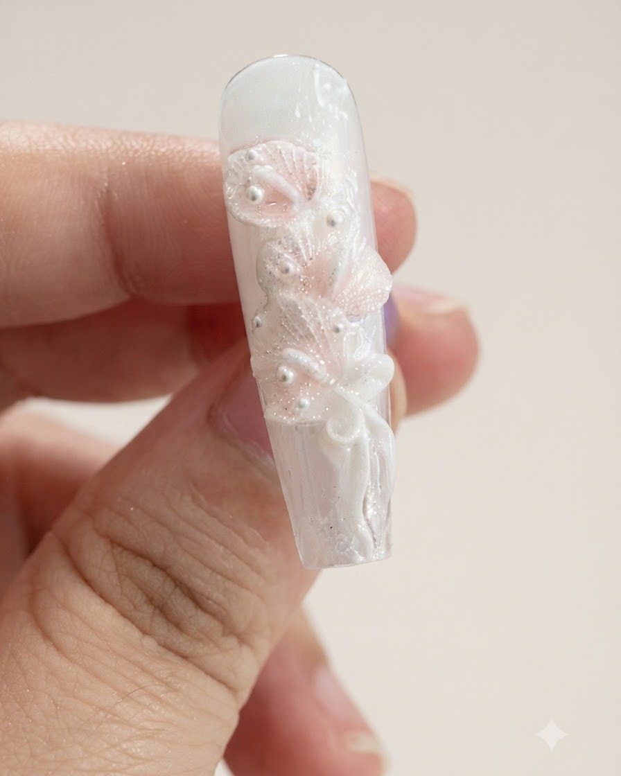 Une vue rapprochée dun ongle comportant plusieurs pétales de lys calla blancs sculptés et un nœud ruban.