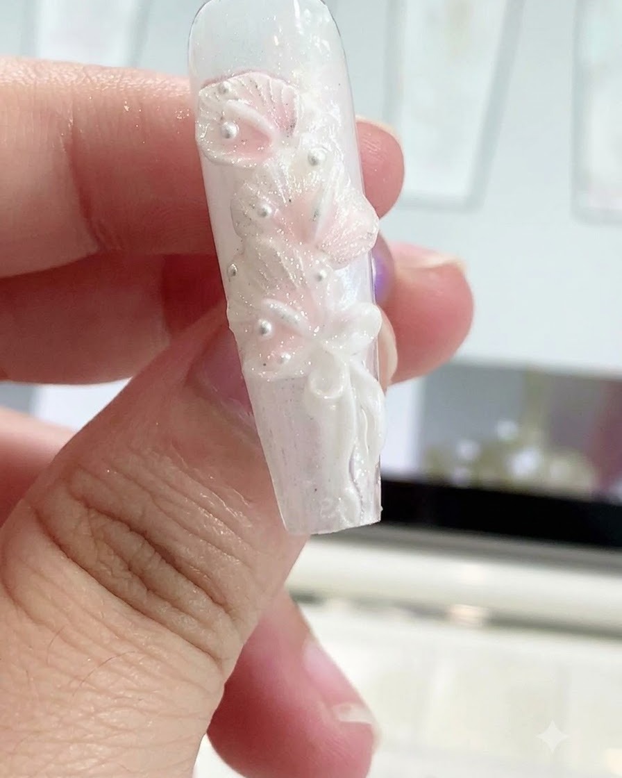 Un stylo de modelage en silicone lissant le centre dun nœud sur un design dongle sculpté.