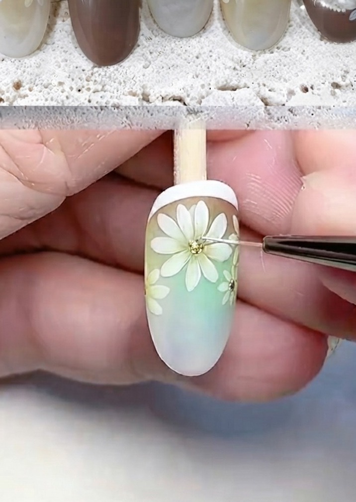 Un outil de précision ajoutant des paillettes et des points blancs au centre dune marguerite peinte.