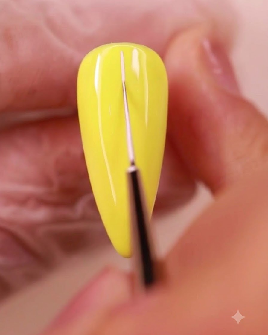 Un pinceau fin traçant de fines lignes de grille blanches sur la surface dun ongle peint en jaune.