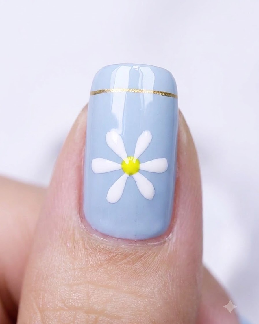 Gros plan dun ongle bleu avec un design de marguerite placé à lintérieur dune lampe de catalysation.